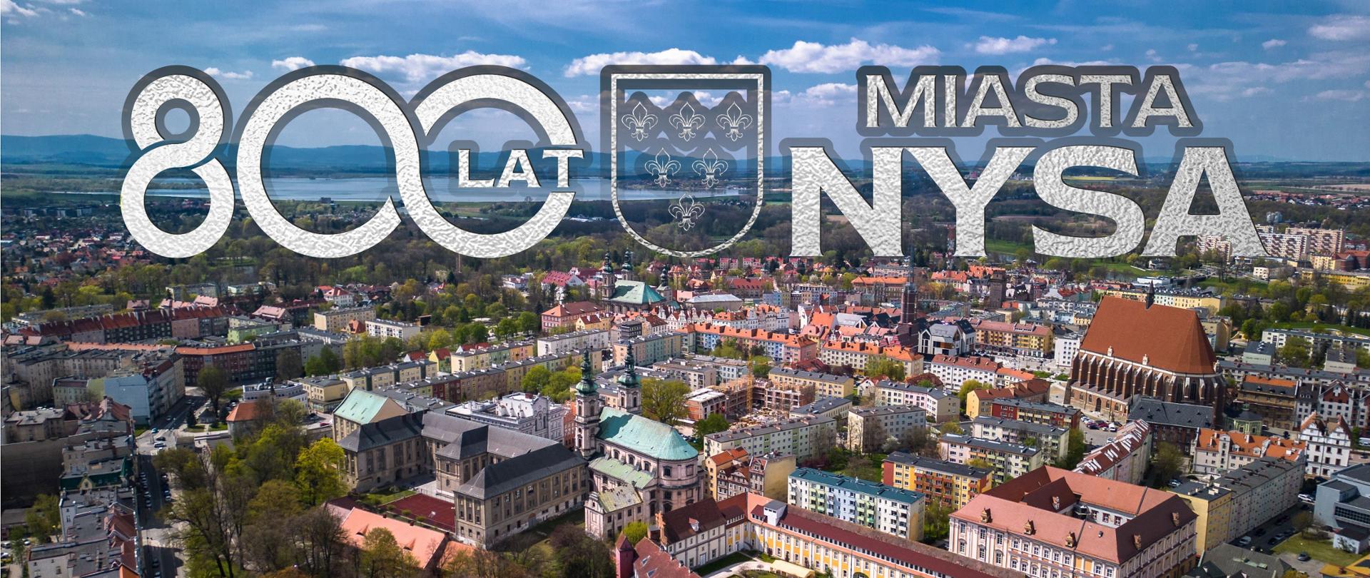 Grafika - afisz. w Górnej części na tle zdjęcia przedstawiającego Nysę z lotu ptaka napisy: 800 lat miasta Nysa wszystkie drogi prowadzą do Nysy. W dolnej części program obchodów. Na dole loga instytucji wspierających organizacje obchodów.