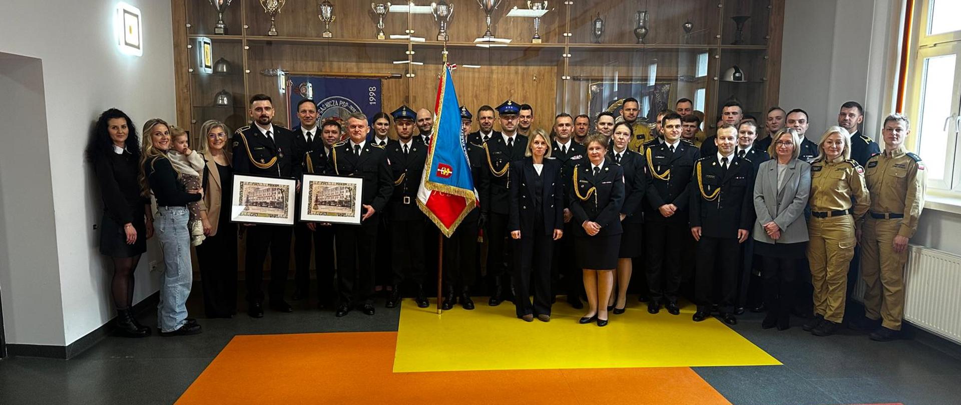 Funkcjonariusze, pracownicy cywilni oraz goście pozują do wspólnego grupowego zdjęcia