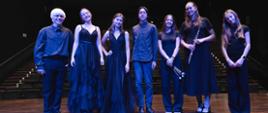 Zdjęcie przedstawia uczestników koncertu we wspólnym zdjęciu na scenie sali koncertowej filharmonii