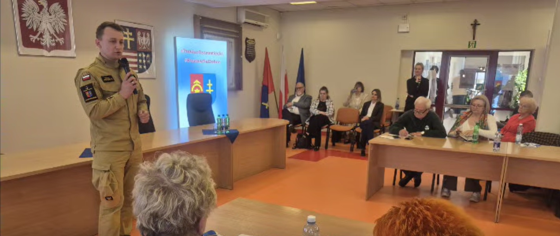 Na zdjeciu widoczny jest przemawiający funkcjonariusz Państwowej Straży Poźarnej.