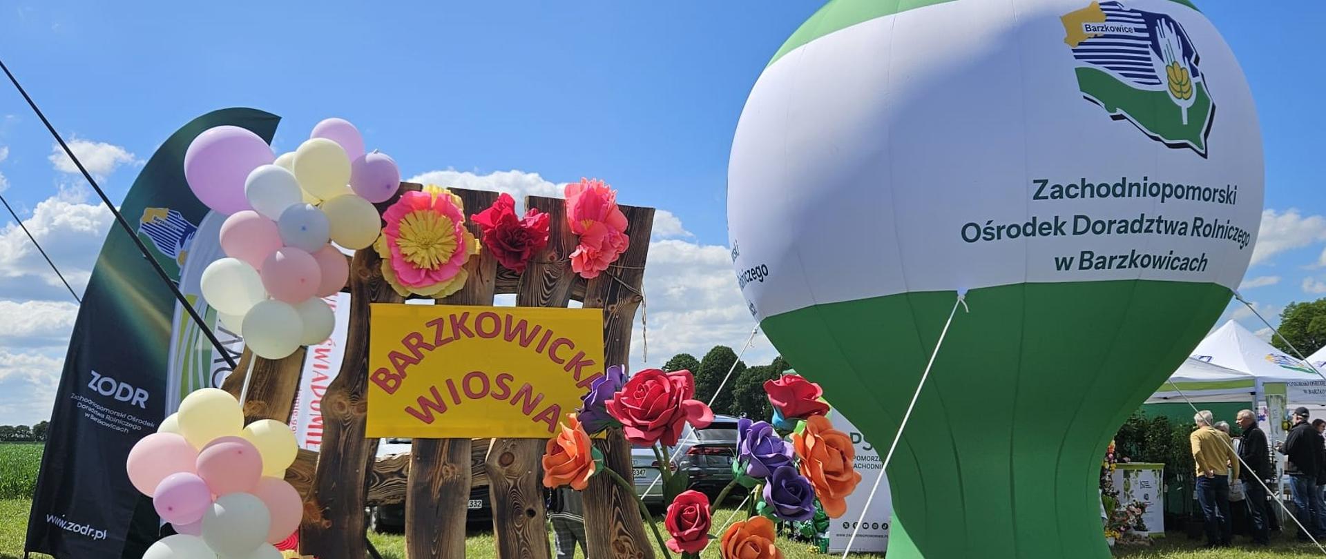 zielony baner z logo ZODR w Barzkowicach i dekoracja ze sztachet z napisem Barzkowicka wiosna