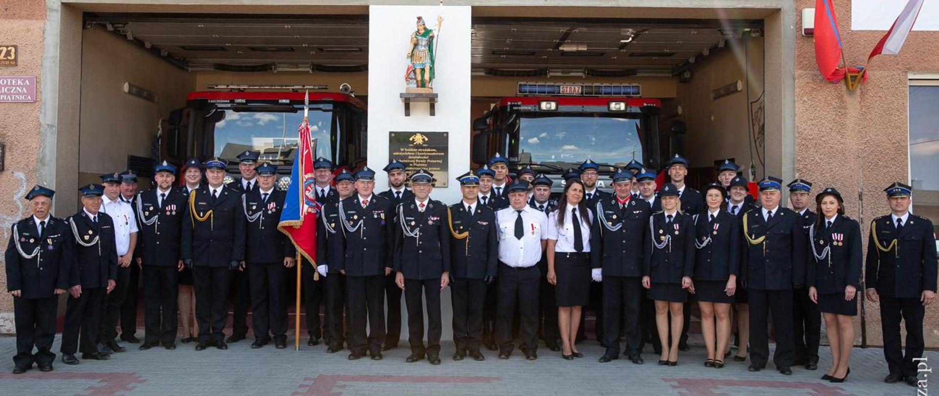 zdjęcie grupowe uczestników uroczystości na tle budynku remizy OSP Piątnica
