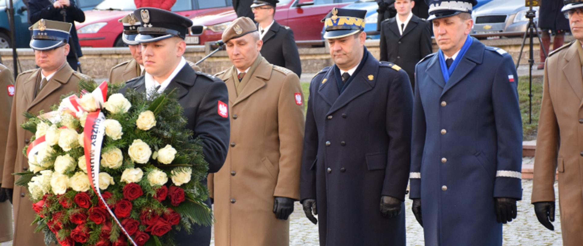 Śląski Komendant Wojewódzki Państwowej Straży Pożarnej nadbryg, Jacek Kleszczewski wraz z przedstawicielami pozostałych służb mundurowych składa wieniec przed pomnikiem Marszałka Józefa Piłsudskiego