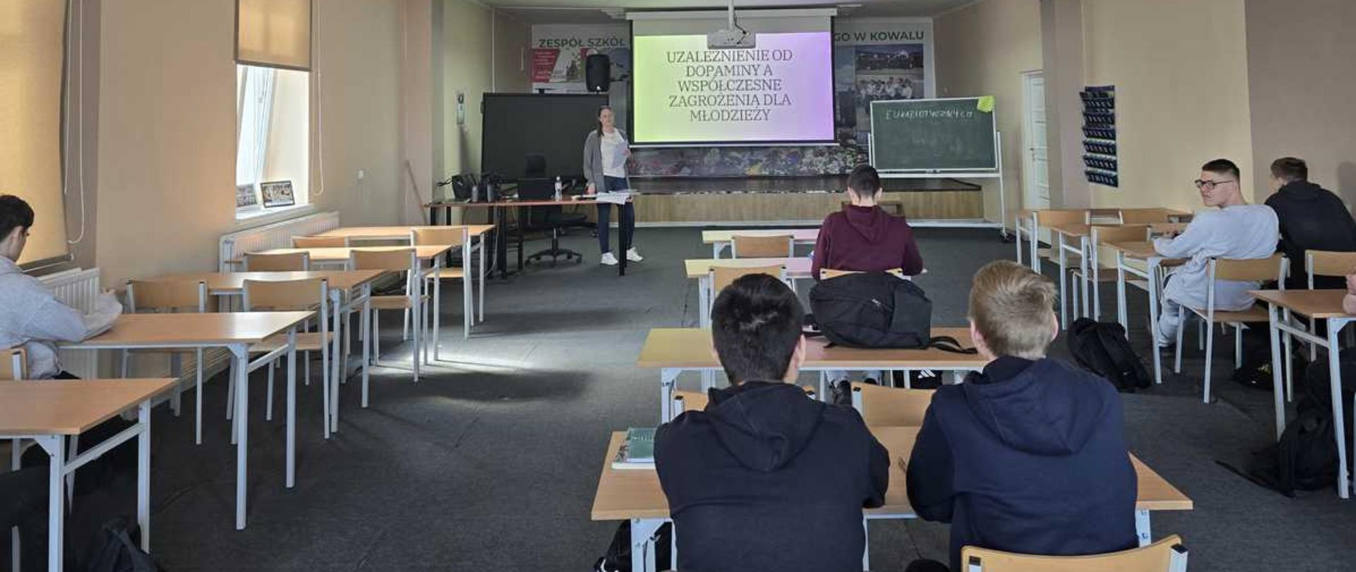 Zdjęcie przedstawia prelekcję edukacyjną dla młodzieży, która odbywa się w Zespole Szkół Centrum Kształcenia Rolniczego w Kowalu. Tematem spotkania jest wpływ dopaminy na funkcjonowanie oraz współczesne zagrożenia, na jakie narażeni są młodzi ludzie.
Kluczowe informacje:
Miejsce: Zespół Szkół Centrum Kształcenia Rolniczego w Kowalu.
Tematyka: Zagrożenia związane z uzależnieniem od dopaminy wśród młodzieży.
Charakter spotkania: Edukacyjna prelekcja zorganizowana w sali lekcyjnej.