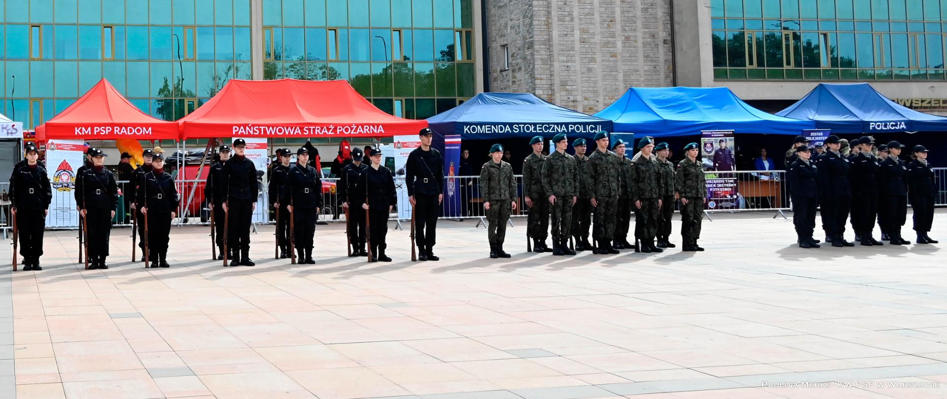 Widok z przodu na pododdziały mundurowe stojące na miejscu wydarzenia