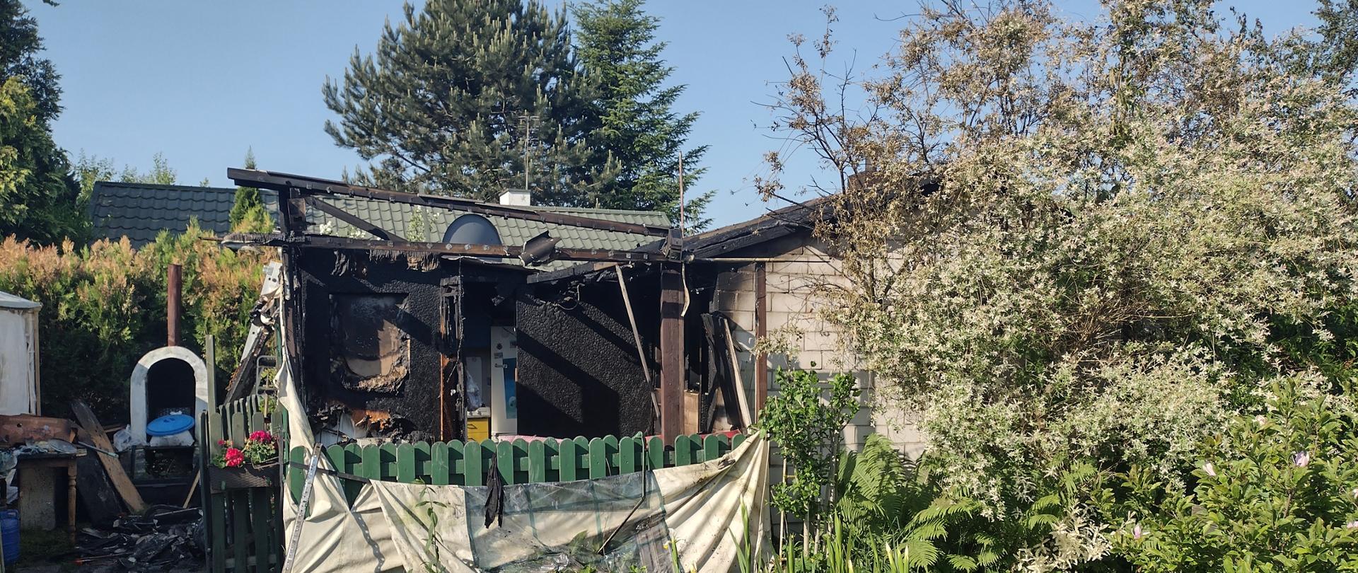 Zdjęcie w ciągu dnia. Widać spalony domek letniskowy.