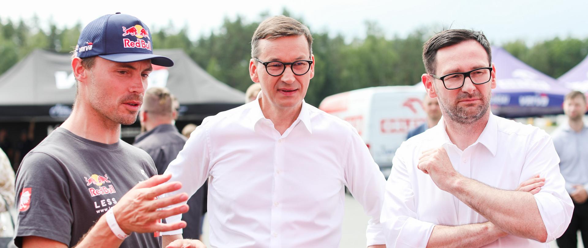 Premier Mateusz Morawiecki rozmawia z kierowcą rajdowym oraz prezesem Orlenu.