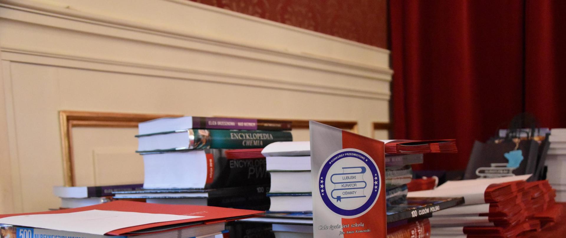 Nagrody książkowe ułożone na stole dla laureatów Konkursów przedmiotowych dla uczniów szkół podstawowych województwa lubuskiego organizowanych przez Lubuskiego Kuratora Oświaty. 