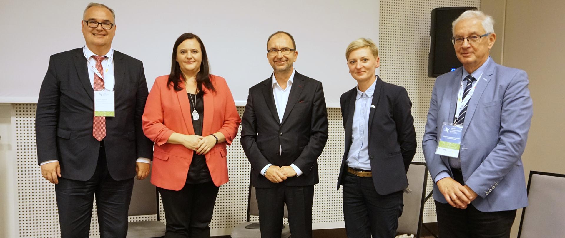 W sali pięć osób pozuje do zdjęcia. Druga od lewej wiceminister Małgorzaty Jarosińskiej-Jedynak