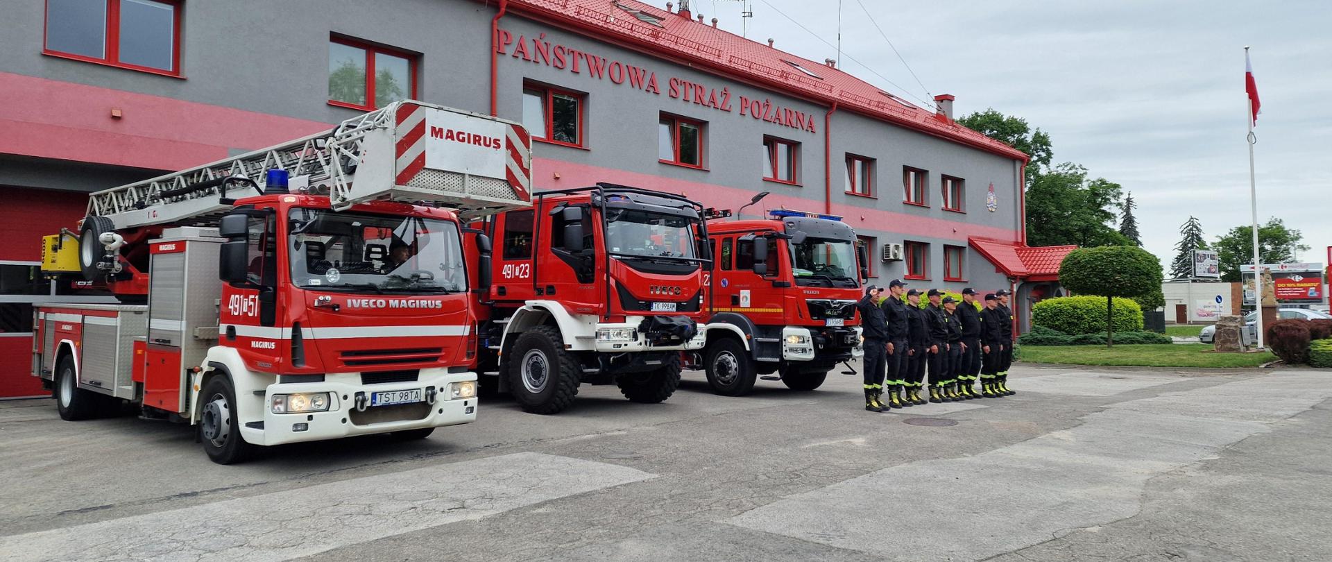 Strażacy w szyku oddają hołd przed strażnicą