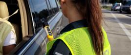 Funkcjonariusz lubuskiej Inspekcji Transportu Drogowego kontroluje trzeźwość kierowcy samochodu osobowego.
