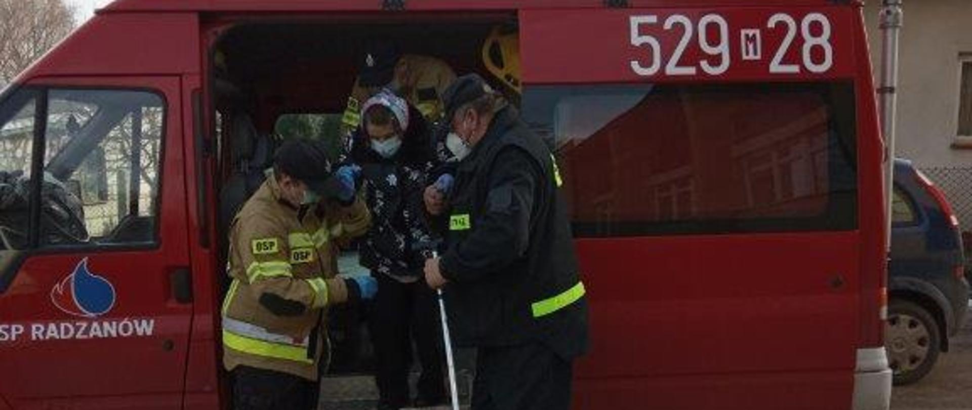 Na zdjęciu strażacy pomaga pacjentowi w dotarciu na szczepienie.