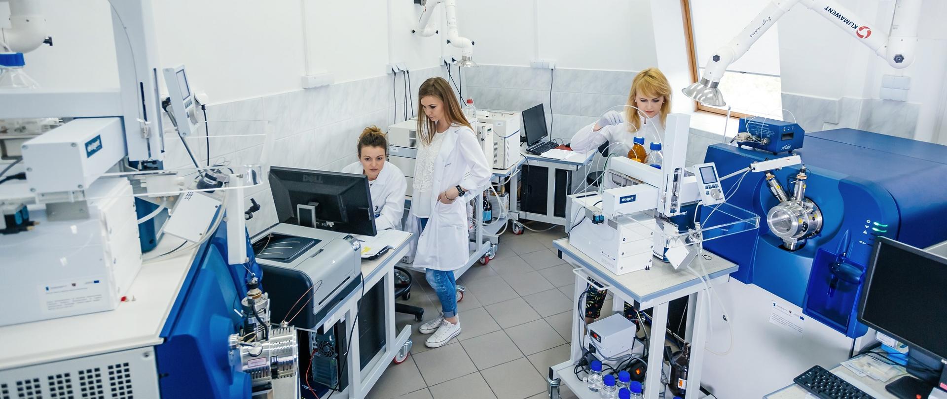 Na zdjęciu trzy kobiety w białych fartuchach w laboratorium.