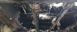 Zdjęcie przedstawia straty po pożarze. Nadpalona konstrukcja dachowa