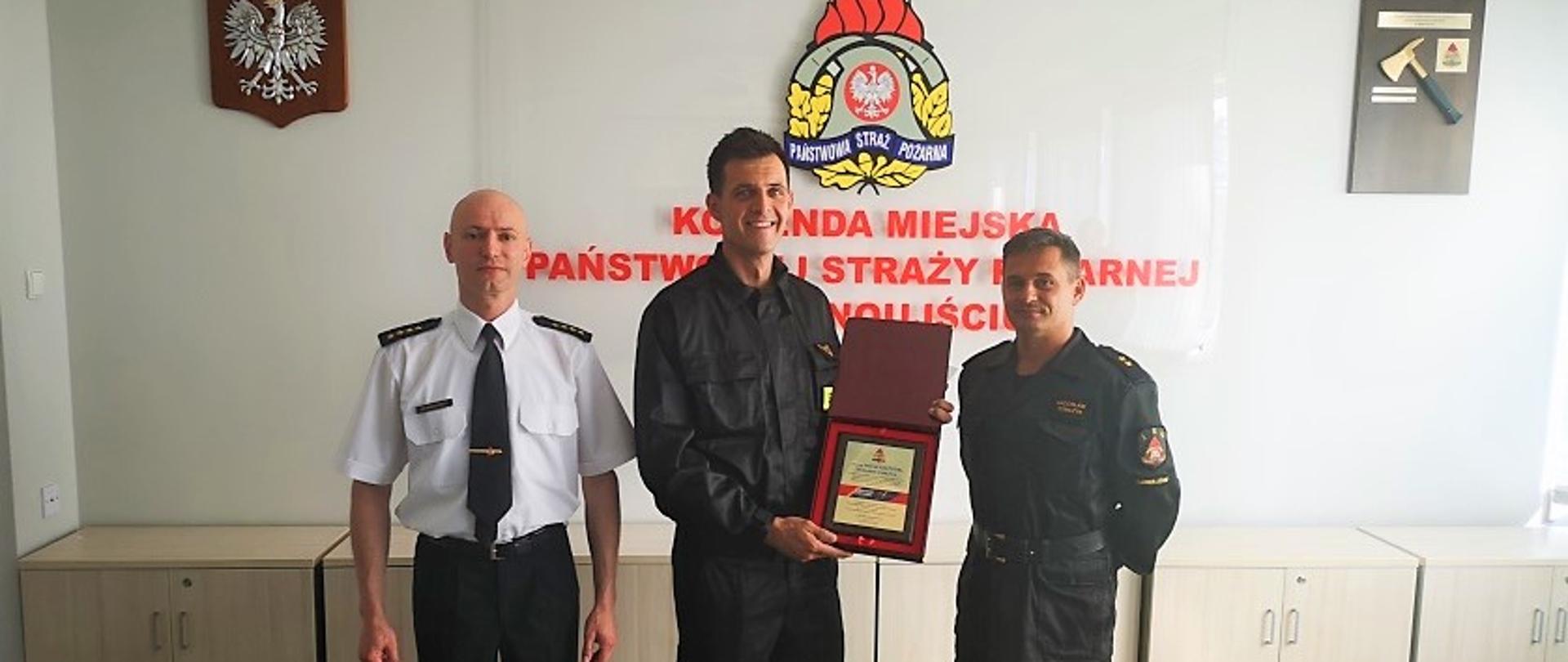 Trzech strażaków w sali konferencyjnej. Z lewej wyróżniony mł. asp. Marek Szczygieł, w środku Komendant Miejski Państwowej Straży Pożarnej w Świnoujściu st. kpt. Marek Wieczorek, z prawej Dowódca Jednostki Ratowniczo Gaśniczej nr 2 w Świnoujściu mł. kpt. Radosław Tomczyk
