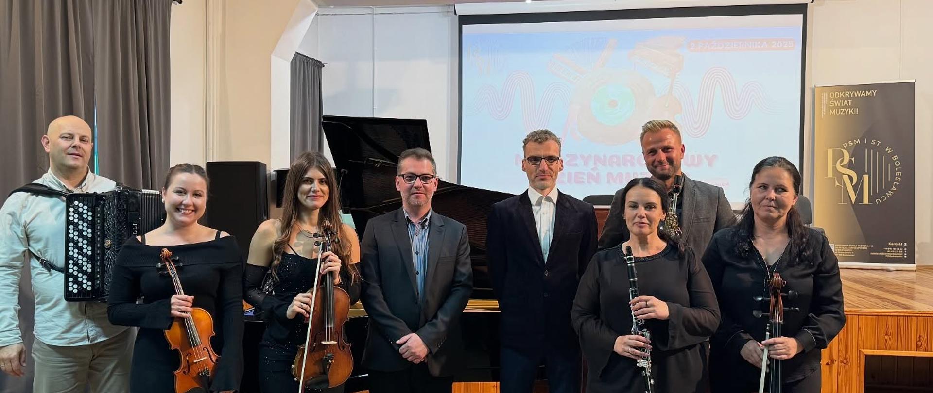 Zdjęcie przedstawiające wykonawców podczas koncertu z okazji obchodów Międzynarodowego Dnia Muzyki, który odbył się w szkolnej auli, 2 października 2025 r.