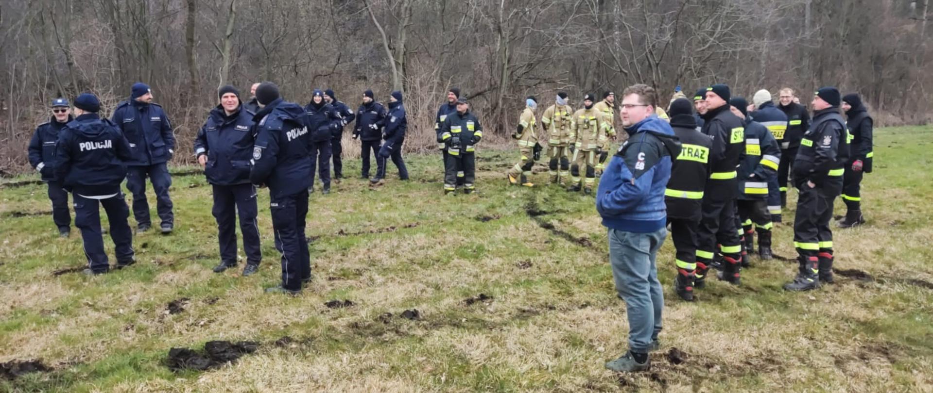 SZCZĘŚLIWY FINAŁ POSZUKIWAŃ. Poszukiwania osoby zaginionej, na zdjęciu widać strażaków, policjantów i osoby cywilne biorące udział w poszukiwaniach.