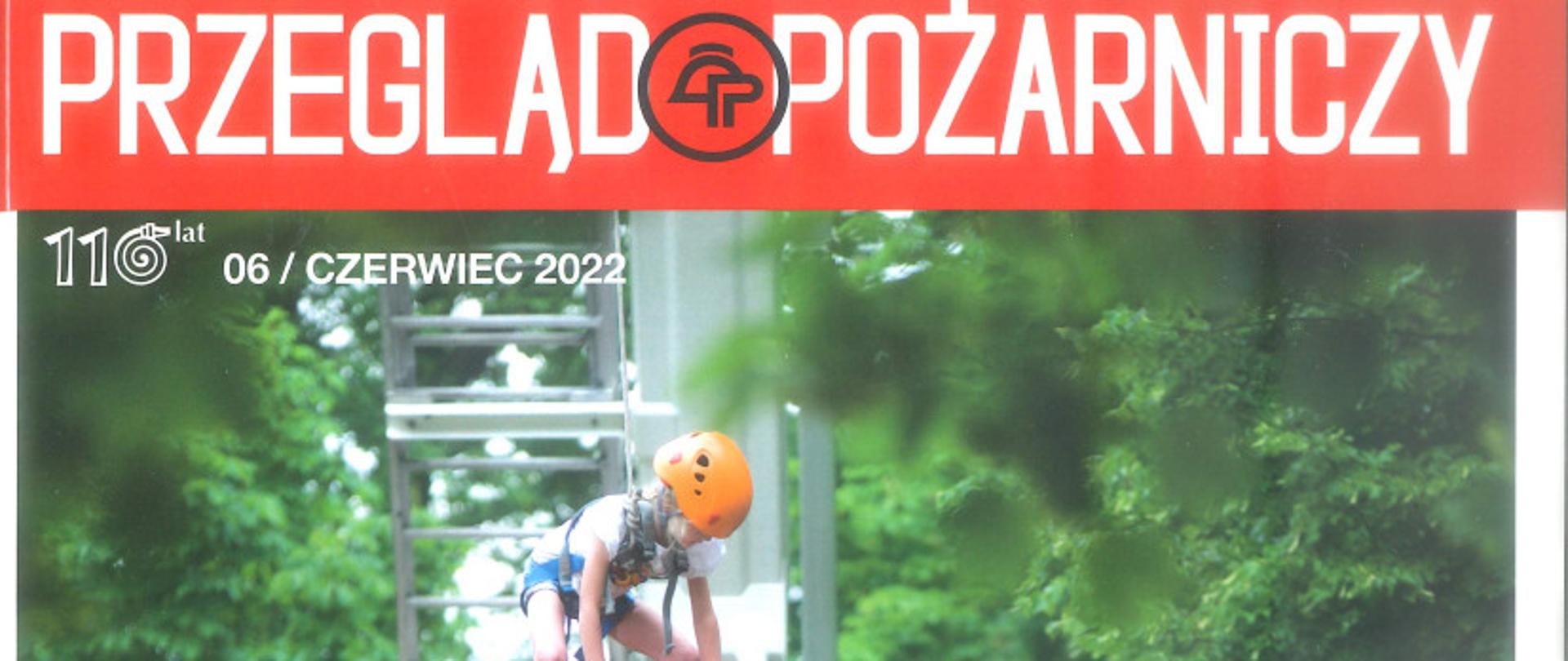 dziecko stojące na kilku czerwonych skrzynkach, przywiązane liną do podnośnika, poniżej przy samochodzie stoi grupa dzieci