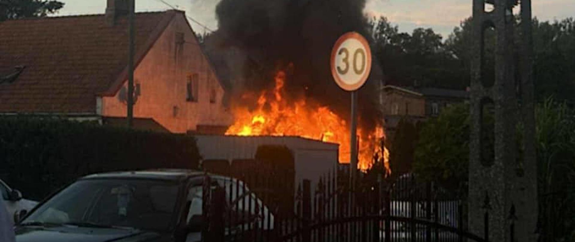 Pożar altany, widać płomienie przy budynku