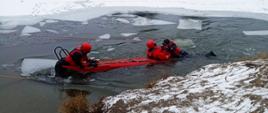 Na zdjęciu strażacy ćwiczą na zalodzonym zbiorniku wodnym