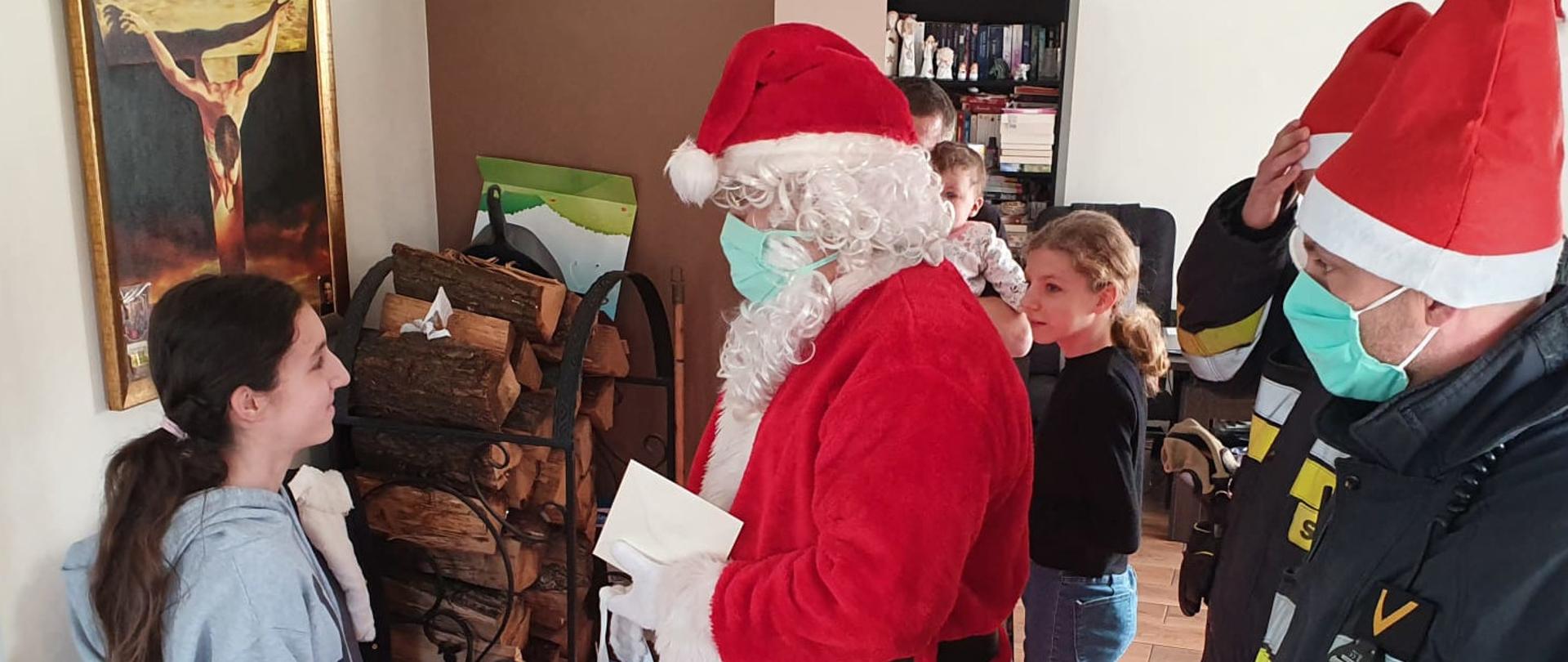 Zdjęcie przedstawia strażaka przebranego za św. Mikołaja