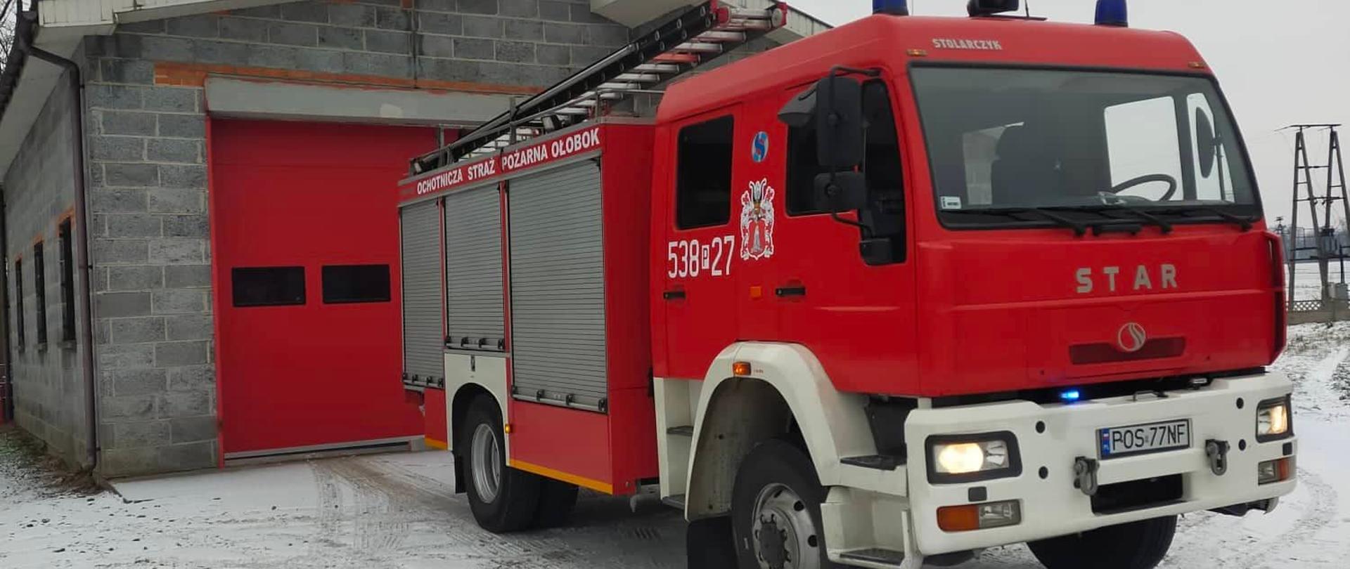 Samochód strażacki na tle remizy OSP Ołobok.