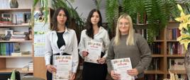 Uczestniczki konkursu pozują z dyplomami w bibliotece szkolnej