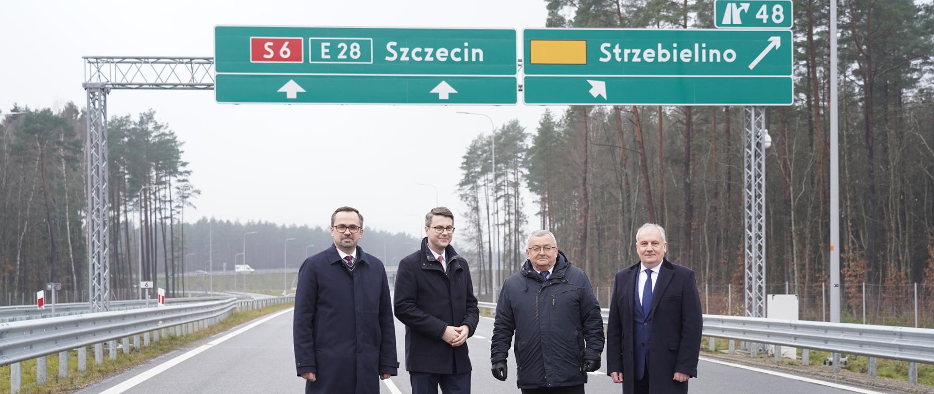 Cztery osoby stoją na środku drogi.