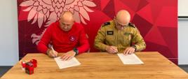 Na zdjęciu prezes WOPR oraz Komendant Powiatowy PSP na tle baneru Komendy Powiatowej PSP w Śremie podczas podpisywania porozumienia 