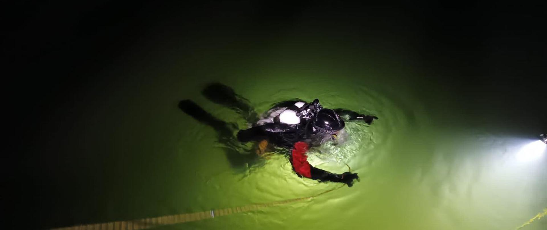 Na zdjęciu widnieją nurkowie podczas szkolenia. Jest noc, ciemno, bez deszczu. 