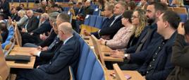 Uczestnicy wydarzenia siedzący na sali wykładowej. 