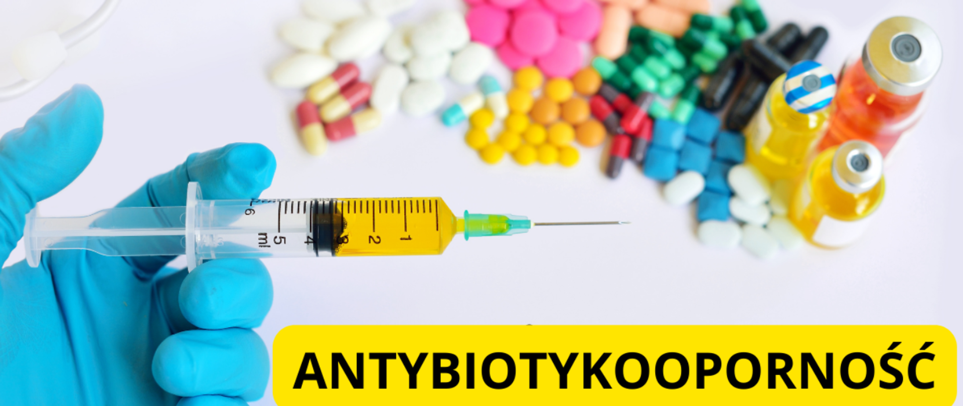 w dłoni strzykawka lekiem, powyżej rozsypane kolorowe tabletki, poniżej napis antybiotykooporność

