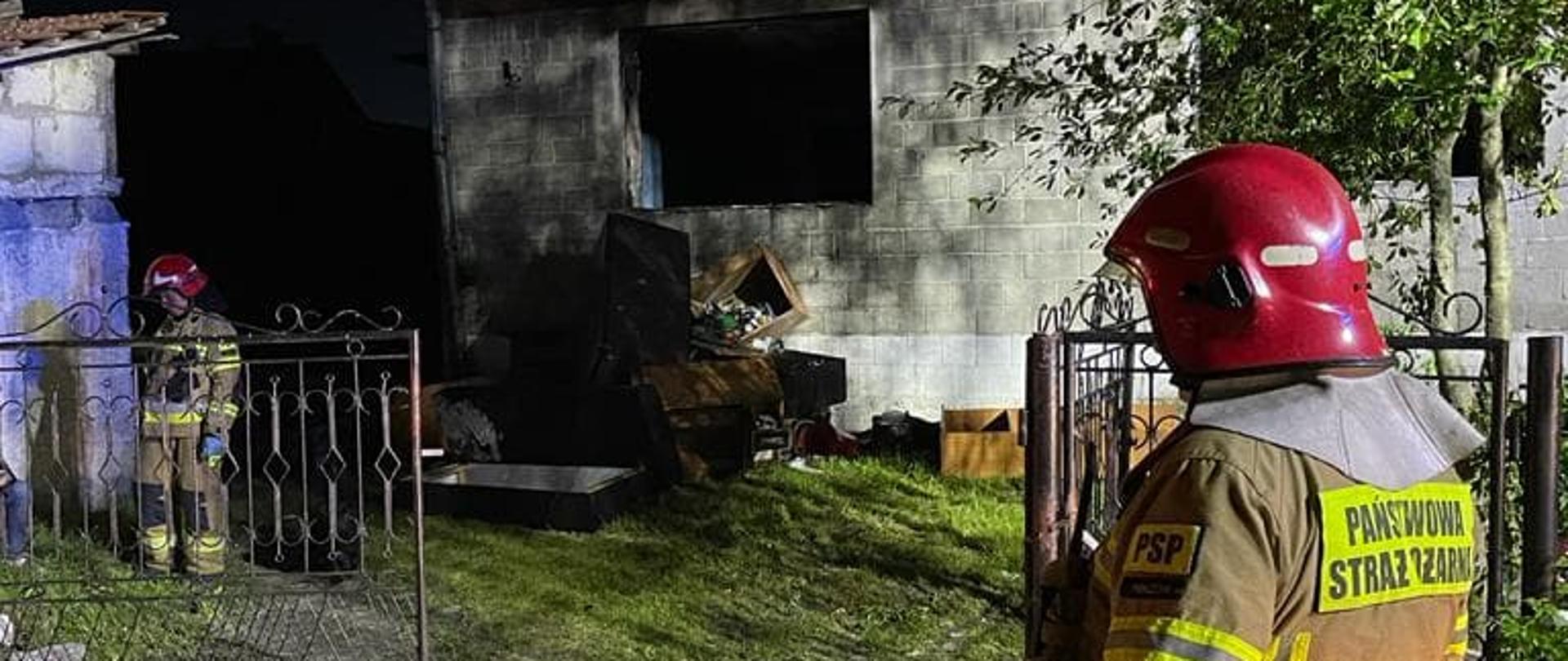 Na zdjęciu widać strażaków prowadzących działania przed budynkiem, w którym doszło do wybuchu gazu propan-butan.
