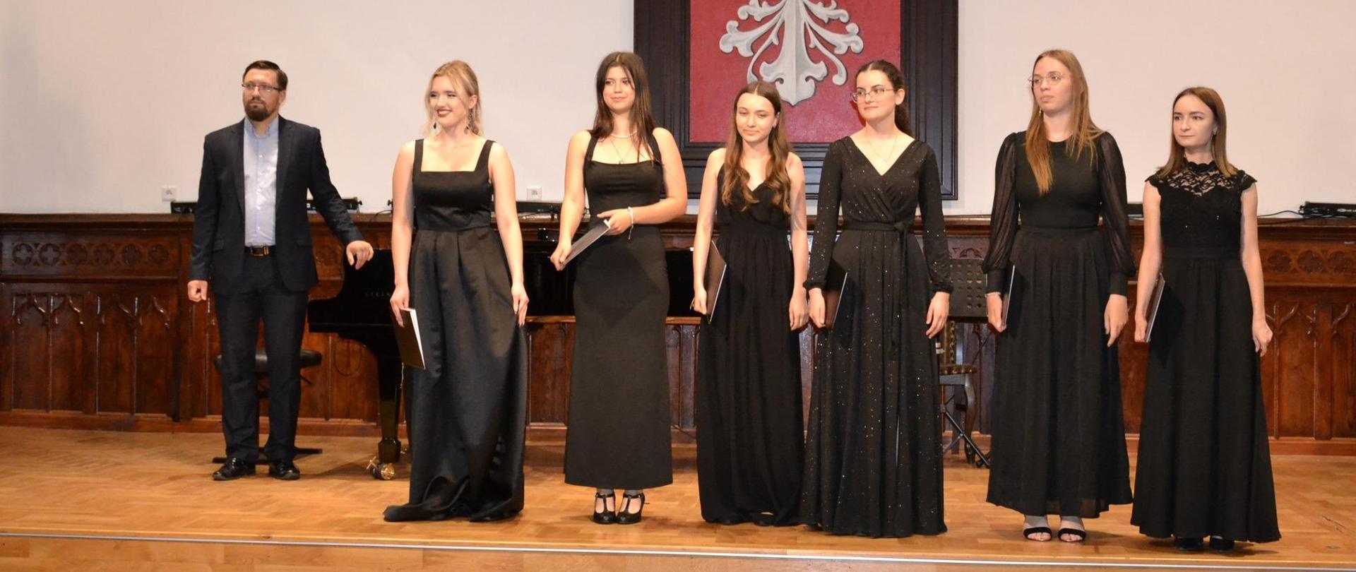 Członkinie zespołu wokalnego wraz z akompaniatorem na scenie w sali królewskiej PSM w mielcu