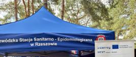 Pracownicy WSSE w Rzeszowie w namiocie przedstawiają eksperymenty związane z wodą dzieciom.