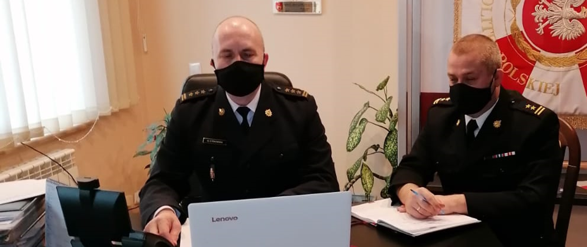 Komendant Powiatowy st. bryg. Grzegorz Łydkowski wraz z Dowódcą Jednostki Ratowniczo-Gaśniczej w Rypinie bryg. Dariuszem Łęgosz brali udział w naradzie rocznej podsumowującej rok 2020, która została przeprowadzona online. W tle sztandar Komendy Powiatowej PSP w Rypinie.