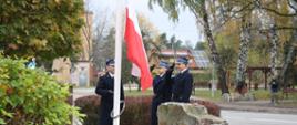 Strażacy wciągający z honorami flagę Polski na maszt.