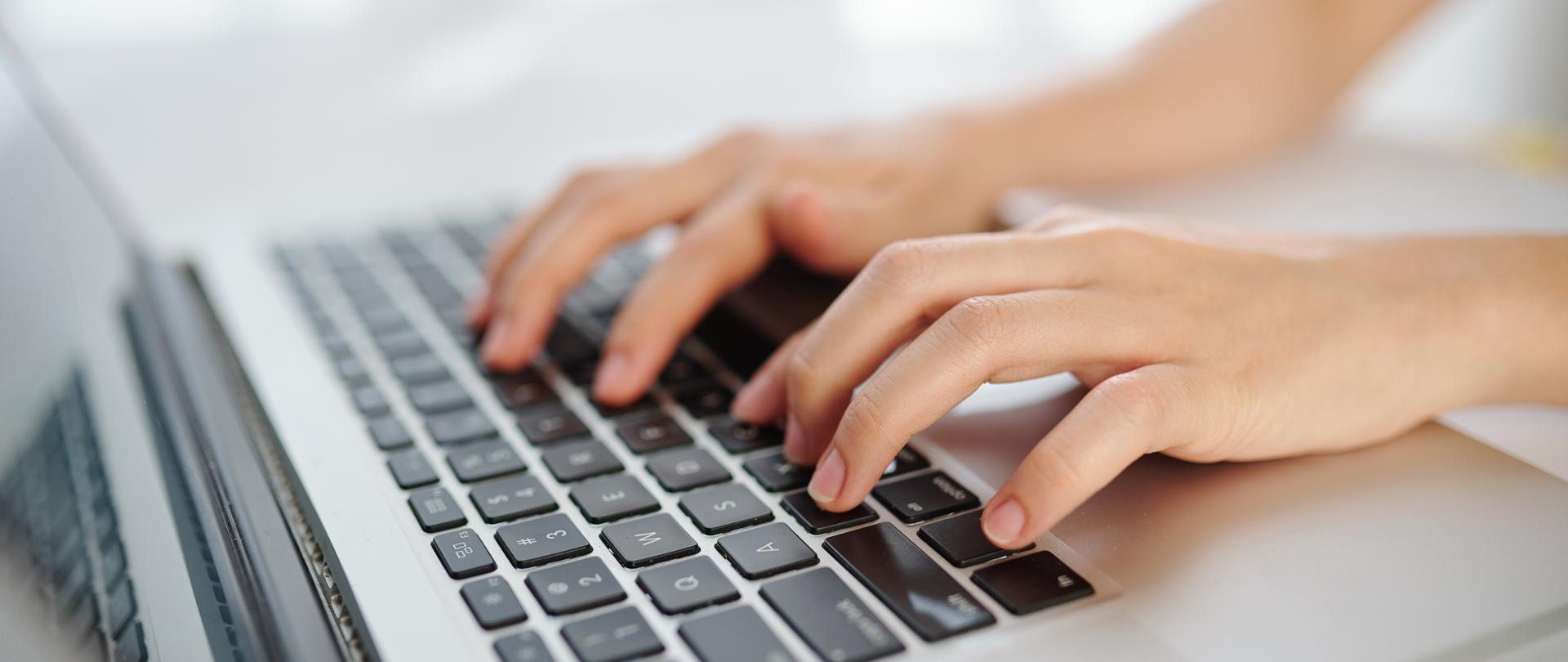 Zdjęcie dłoni kobiecych na klawiaturze laptopa