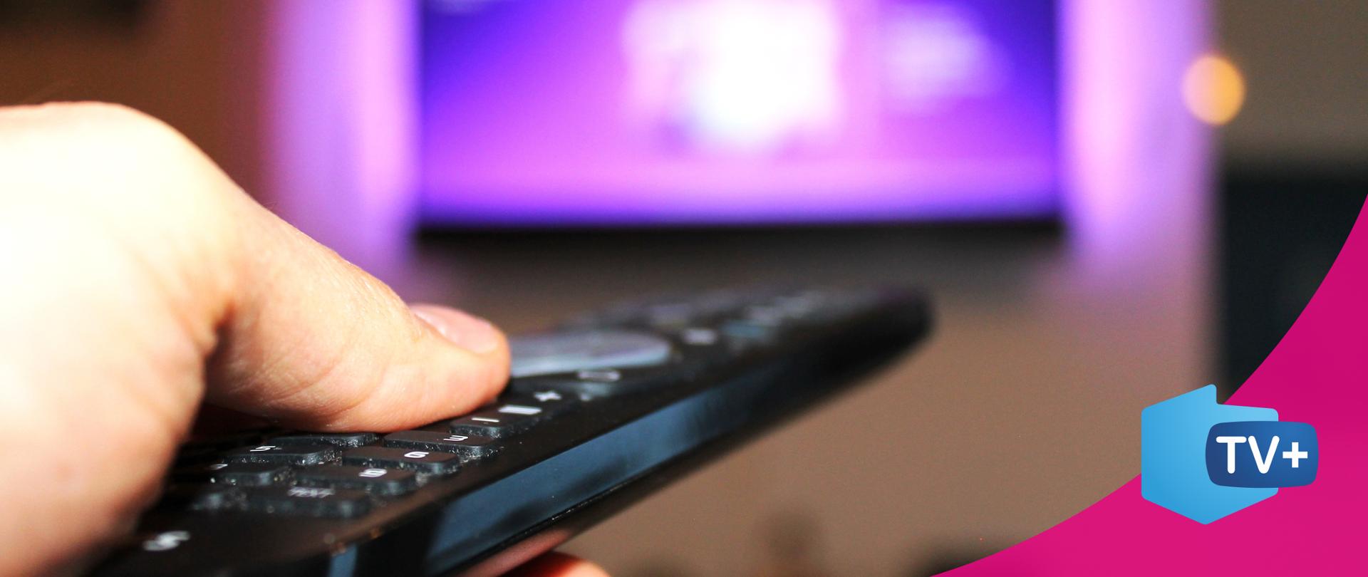 Dłoń z pilotem, telewizor 