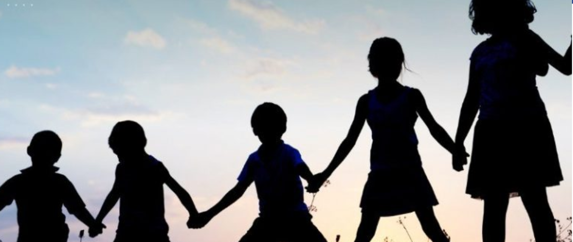 grupa dzieci na łące, widoczne tylko ich zarysy sylwetek