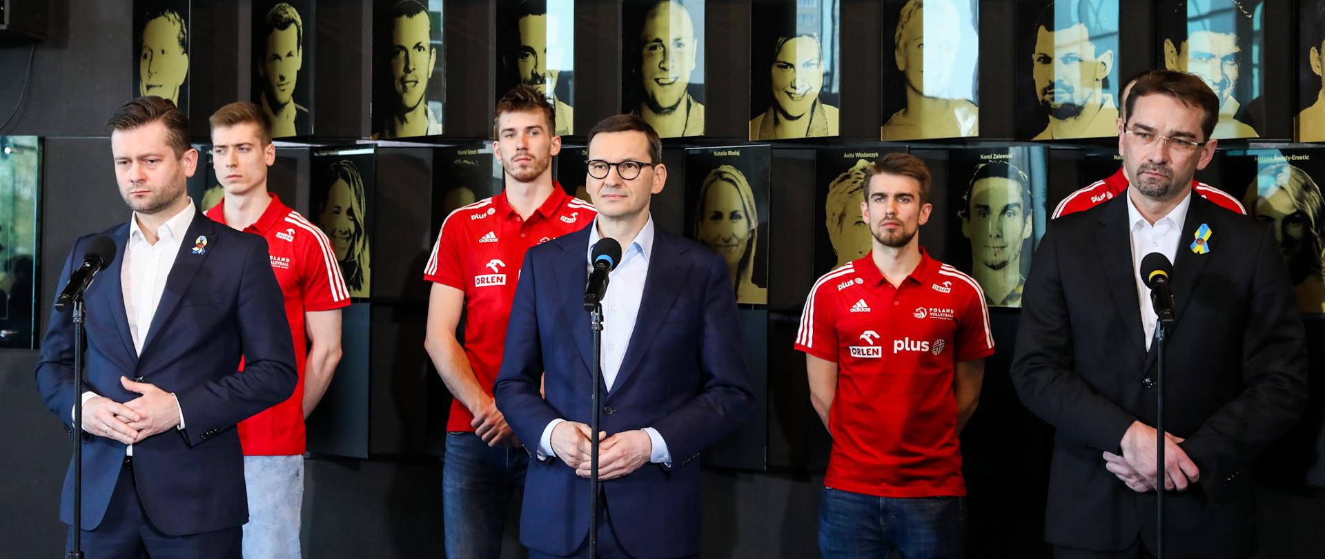 Minister sportu, premier Mateusz Morawiecki oraz prezes PZPŚ stoją podczas konferencji prasowej.