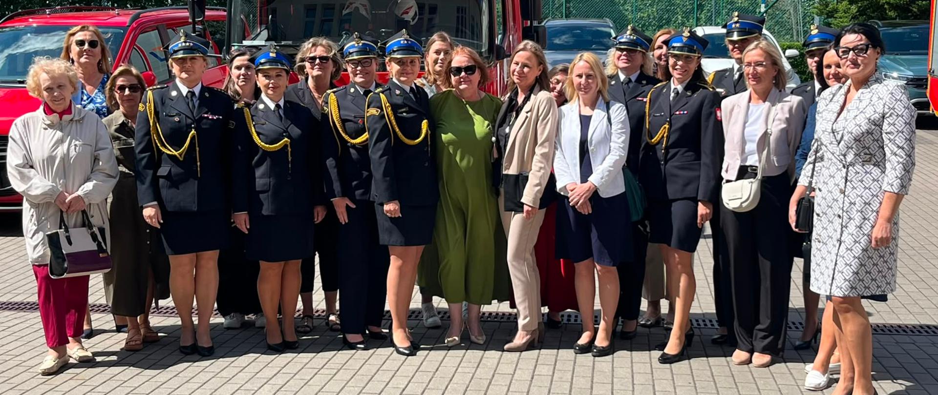 Grupa kobiet, strażaczek pozuje do zdjęcia.
