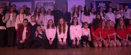 Uczniowie z opiekunami na scenie, pośród nich Komendant Policji i Wicewojewoda Zbigniew Szczypiński.