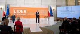 Prezydent Andrzej Duda przemawia na scenie, za nim napis Lider dostępności 2021. Kadr obejmuje również publiczność.