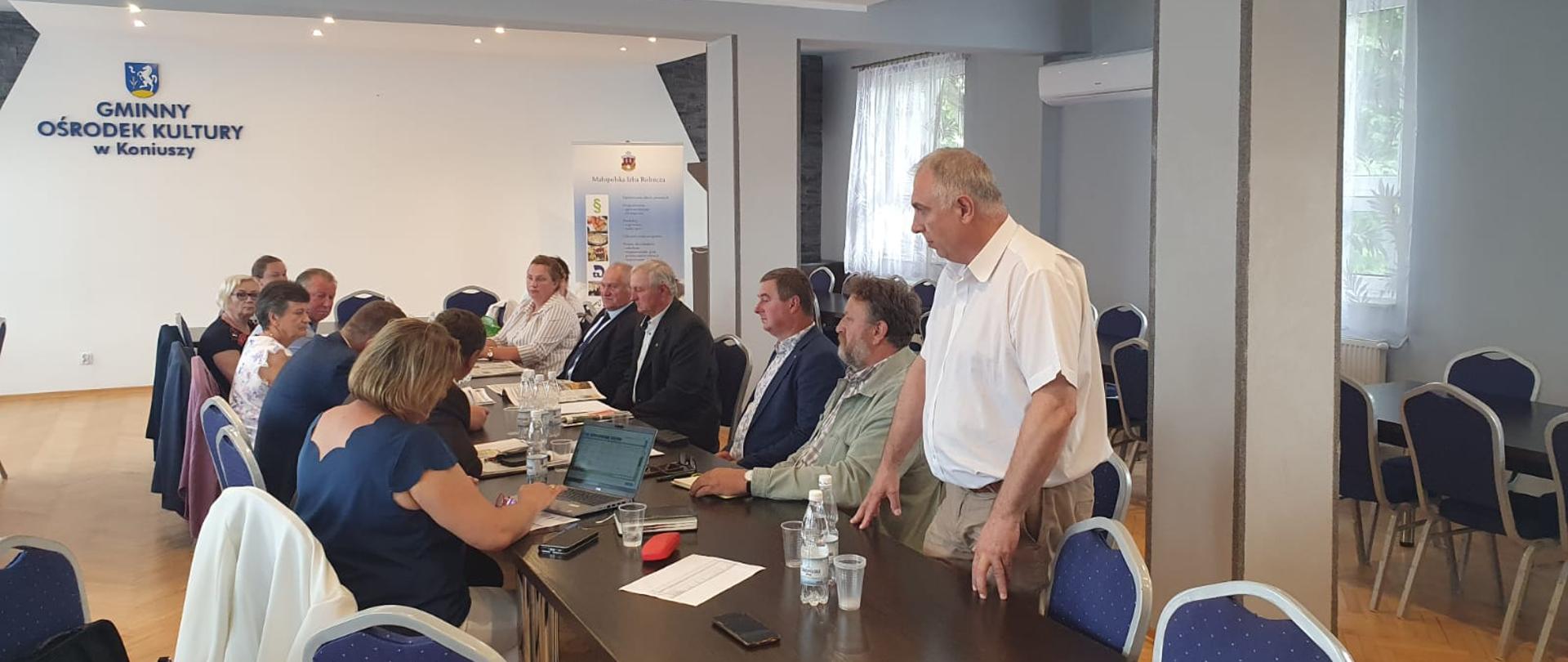 Na zdjęciu wystąpienie inspektora WIORiN w Krakowie Oddział w Proszowicach na posiedzeniu MIR w Koniuszy.W tle obok po prawej i lewej stronie widać uczestników posiedzenia