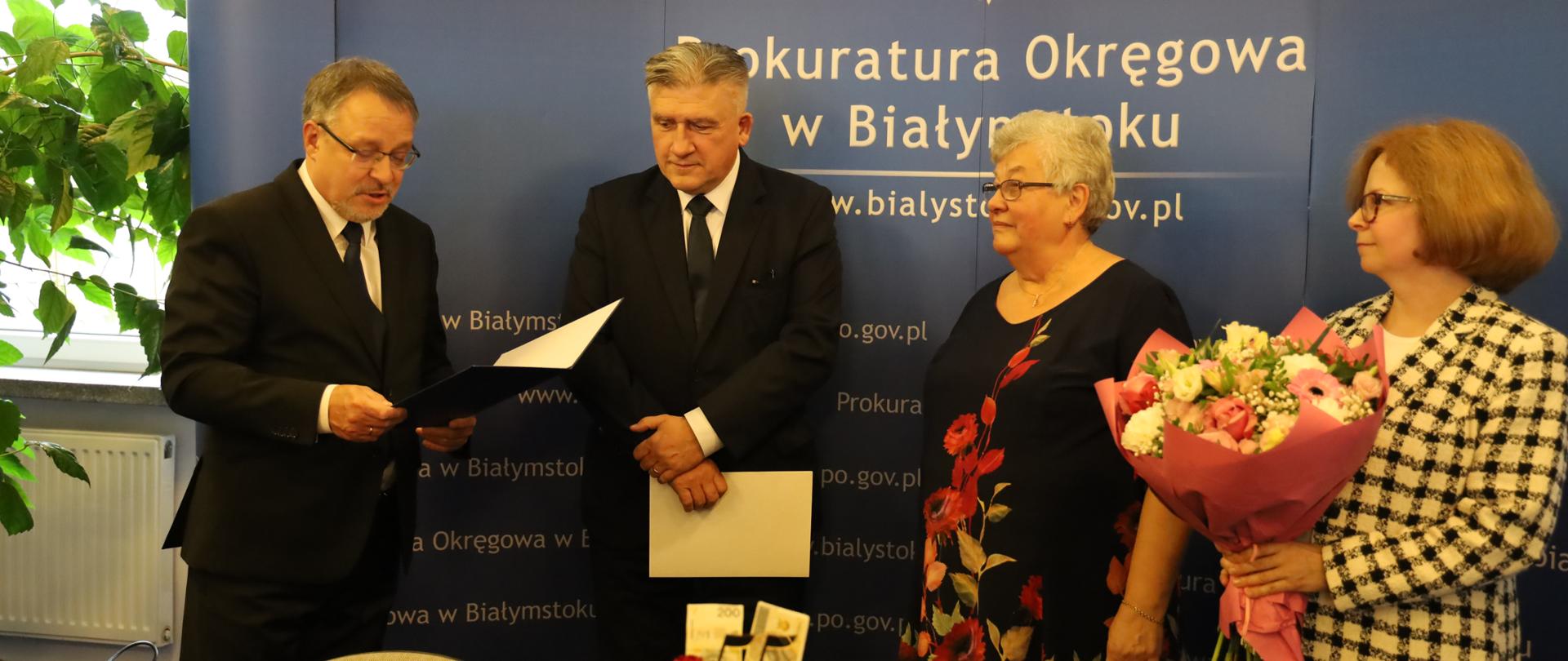15 października 2024 r. w Prokuraturze Okręgowej w Białymstoku miał miejsce wyjątkowy jubileusz – Starsza Inspektor Wydziału Administracyjno-Finansowego Prokuratury Okręgowej w Białymstoku Pani Maria Żobel świętowała 55-lecie swojej pracy w prokuraturze. W dniu 17 lipca 2024 roku w Prokuraturze Regionalnej w Białymstoku odbyło się Zgromadzenie Prokuratorów. Na zdjęciu od strony lewej list gratulacyjny nadesłany przez I Zastępcę Prokuratora Generalnego Prokuratora Krajowego Dariusza Korneluka odczytuje Pan Prokurator Regionalny w Białymstoku Tadeusz Marek, następnie obok stoi Pan Prokurator Okręgowy w Białymstoku Mirosław Żoch, Pani Maria Żobel oraz Pani Zastępca Prokuratora Okręgowego w Białymstoku Joanna Dąbrowska.