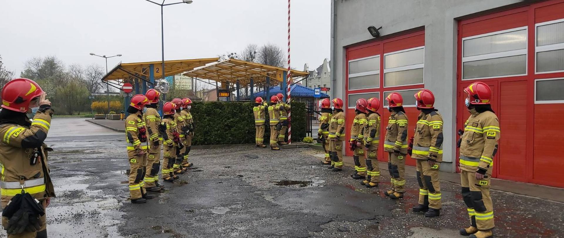 Na zdjęciu są strażacy oddający honor podczas wciągania flagi na maszt