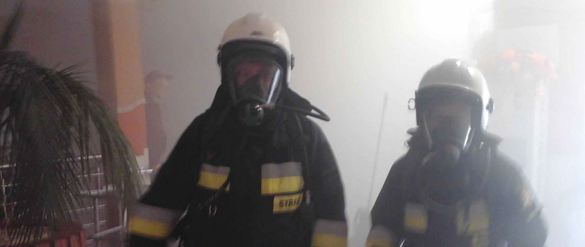 Ewakuacja pensjonariuszy- zadymienie pomieszczenie, strażacy pracujący w sprzęcie ochrony układu oddechowego.