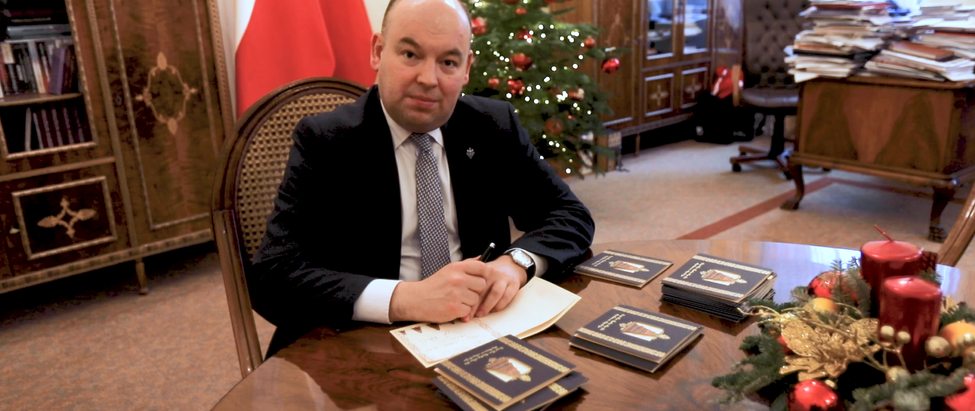 Minister Jan Dziedziczak podpisujący kartki z życzeniami świątecznymi, KPRM grudzień 2021