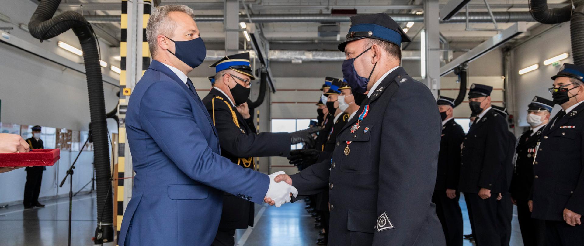 mężczyzna w garniturze i mężczyźni w mundurach strażackich